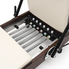 Foldable Pilates Reformer Flexi, dark wood, milky white upholstery – springs and footbar