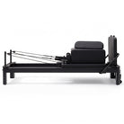 Pilates reformer aluminum all black, side view with sitting box