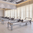 Pilates reformer aluminum milky white, in a studio
