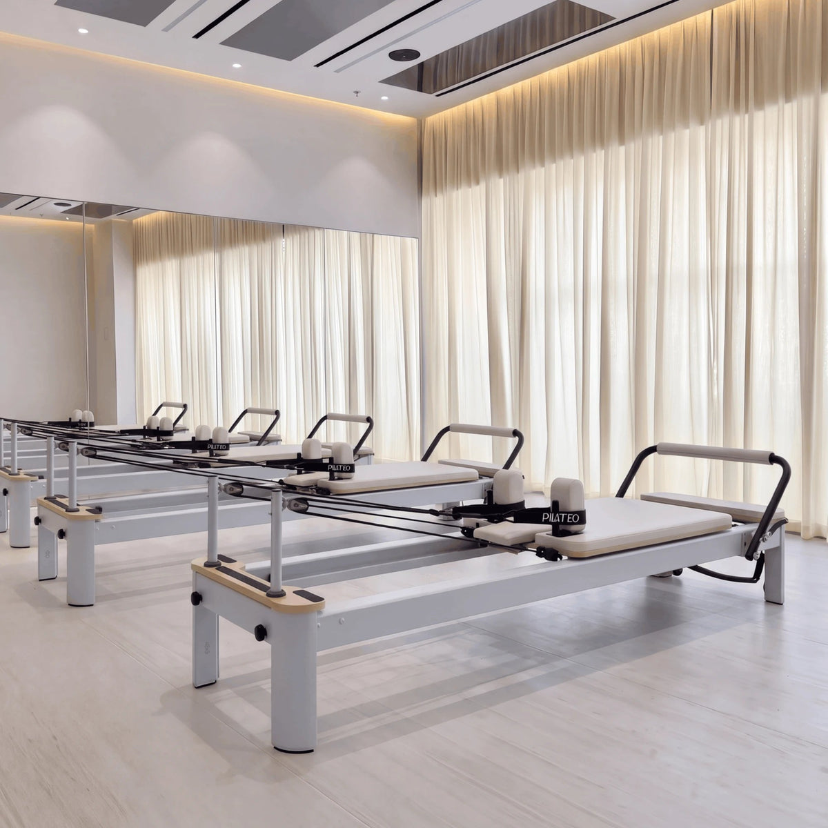 Pilates reformer aluminum milky white, in a studio
